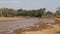 The Views Of The African River With Brown Water And Shore Of Lush Bushes