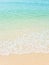 Views of beautiful white sand beaches and turquoise waters. Summer vacation beach background. Waves of the sea on a vertical sandy
