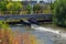 Views of Jordan River Trail Pedestrian and Train Track Bridge with surrounding trees, Russian Olive, cottonwood and muddy stream a