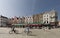 Views of the market square in the city of Bruges with people going by bike in the foreground.