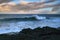 Views of the sea and black lava rocks at sunset