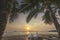 Views of sunrise with cushions and coconut palm trees on tropical beach background