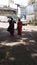 Views of two old women walking in the school street