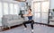 Vigorous energetic woman doing squat weight lifting exercise at home.