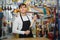 Vigorous young salesman in apron with tools