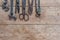 Viiew of vintage rusted tools on old wooden table: pliers, pipe wrench, screwdriver, hammer, metal shears, saws and other.