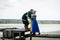 Viking family on a pier on a lake. wife and daughter hug and kiss a man.