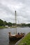 Vikings` boat with mast and shields on the board moored in the Neva River