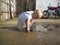 Village boy playing in a dirty puddle next to a barn in a grandmothers yard