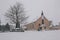 Village church covered in snow during Storm Emma, also known as the Beast from the East, with crows flying away.
