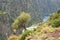 A village on the edge of a canyon of Valley of the Butterflies beach from above, in the village of Faralya