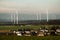 Village in front of panorama view over wind farm landscape in Germany with white generator turbines