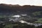 Village of Furnas at sunrise with a fog mist of gases and steams from several fumaroles, calderas and thermal pools