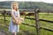 Village girl with a bag of milk and bread going through the fields with grazing cows. Summer rural life in Germany.