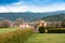 village houses on green fields and hedge under a cloudy blue sk