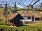 Village huts with grassy green surrounding and wooden wine barrel in the yard