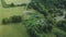 Village in the middle of the forest. Rural landscape. Roofs of houses are visible among the trees. Aerial photography