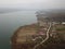 Village near the lake seen from the drone in early spring. aerial capture on a foggy day