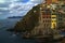 Village of Riomaggiore, rocks and sea covered by clouds. Cinque Terre, Italy