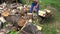 Villager man guy load chopped firewood to rusty wheelbarrow. 4K