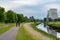 Vilvoorde, Flemish Brabant, Belgium - Cyclist on a bicycle trail at the banks of the river Senne with two powerplant chimneys in