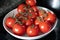 Vine ripe tomatoes in a white bowl on a granite counter