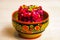 Vinegret Russian beet salad of boiled vegetables in painted wooden bowl on white table background