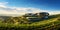 Vineyard landscape with a modern winery building on a hill under stunning sky. Rows of grapes. Generative AI