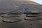 Vineyards dug in holes in the ground with a protective wall against the wind at Lansarote Island. Canary Islands.