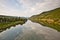 vineyards at the hills of the romantic river Mosel edge in summer with fresh grapes and reflection in the river