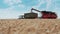 VINNYTSIA, UKRAINE - JULY 19, 2020: Unloading the collected grain from combines to tractors with trailers.