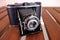 Vintage Agfa photo camera on a wooden table, lens contraption open