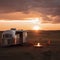 Vintage Airstream Trailer Parked in the Middle of a Sprawling Prairie Landscape with Sunset View