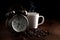 Vintage alarm clock with white coffee cup and coffee beans, on brown cloth and have black background