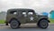 Vintage American Military Vehicle Parked on Seafront Promenade in front of Beach Hut.