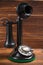 Vintage, antique candlestick telephone with dial on wood background