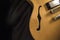 Vintage archtop guitar in natural maple close-up from above on black background, F-hole detail