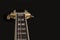 Vintage archtop guitar in natural maple close-up high angle view on black background, rosewood fingerboard with frets and fret