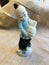 Vintage Asian Man Figurine with Pottery Pot and a Top Knot on Burlap background