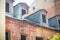 Vintage attic windows on red brick wall building roof