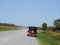 Vintage automobile cruising on dirt road in summer day