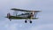 Vintage Avro 621 Tutor biplane Aircraft in flight cloudy sky.