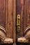 Vintage background. Brass-made old handle with Elements of an carved wooden door decorated with massive wooden