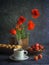 Vintage background with red poppies in a wooden vase, a cup of coffee, strawberries in a plate and croissants on a wooden tray