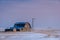 Vintage barn, bins and windmill surrounded by snow under pink sunset sky in Saskatchewan