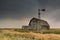 Vintage barn, bins and windmill under ominous dark skies in Saskatchewan, Canada