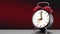 Vintage black alarm clock on red background. Time concept.