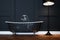 Vintage black bathtub with silver legs in antique interior with