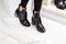 Vintage black patent leather shoes with silver heel on female legs. Youth design of the new autumn-spring collection womens boots