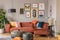 Vintage black poufs in trendy eclectic living room interior with brown couch